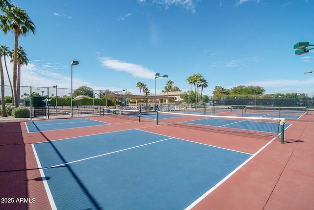 view of tennis court featuring community basketball court and fence