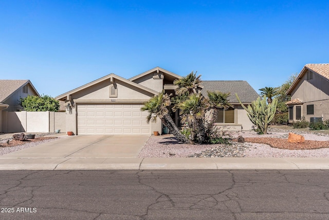 view of front facade featuring a garage, concrete driveway, fence, and stucco siding