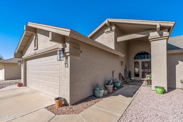 exterior space with a garage, driveway, and stucco siding