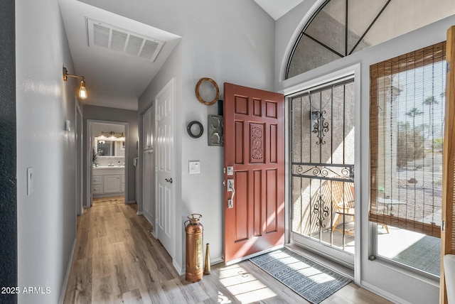 entryway featuring wood finished floors, visible vents, and baseboards