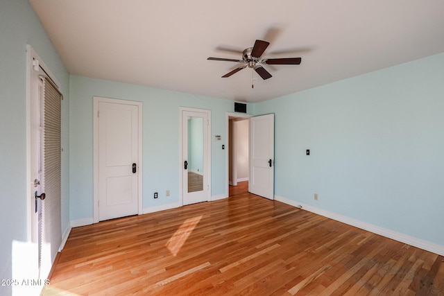 unfurnished bedroom with two closets, ceiling fan, and light hardwood / wood-style floors