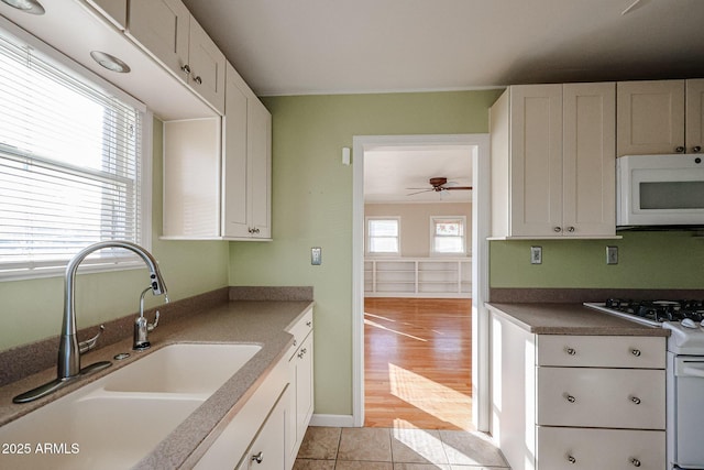 kitchen featuring white cabinetry, white appliances, and sink