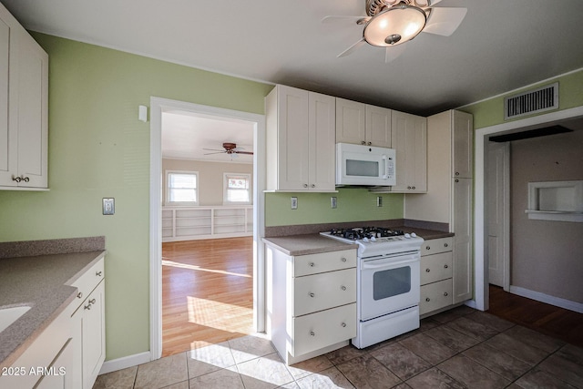 kitchen featuring tile patterned floors, white appliances, and white cabinetry