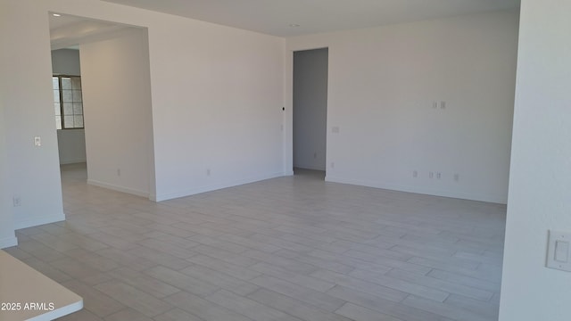 spare room featuring wood finished floors and baseboards