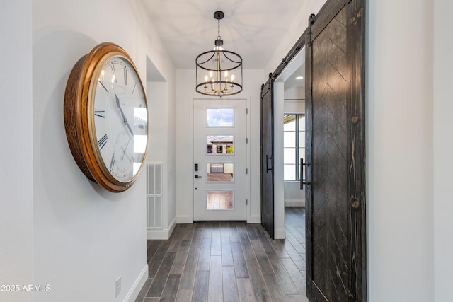 3281 Maverick Dr, Wickenburg, AZ 85390 - entrance foyer with baseboards, a barn door, dark wood-style flooring, and a notable chandelier