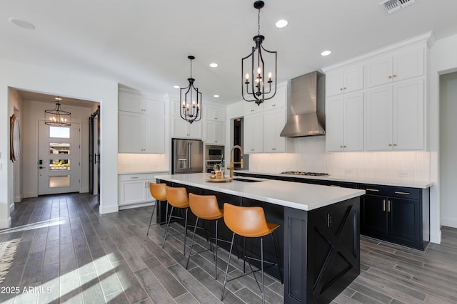 3281 Maverick Dr, Wickenburg, AZ 85390 - kitchen featuring a sink, high end fridge, wall chimney exhaust hood, gas cooktop, and an inviting chandelier