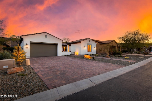 3281 Maverick Dr, Wickenburg, AZ 85390 - mediterranean / spanish-style house with stucco siding, an attached garage, a tiled roof, and decorative driveway