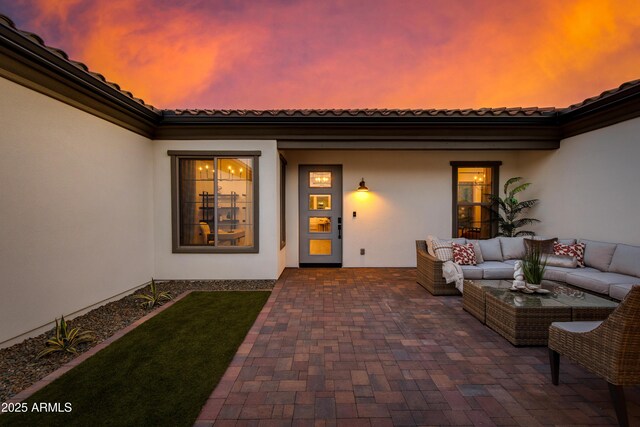 3281 Maverick Dr, Wickenburg, AZ 85390 - view of exterior entry with an outdoor hangout area, stucco siding, a patio area, and a tiled roof