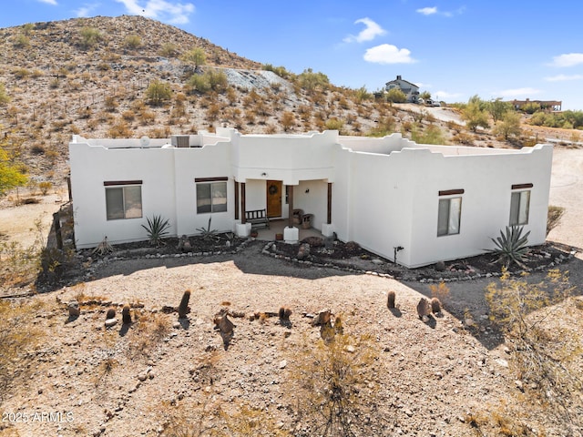 pueblo-style home with a mountain view and stucco siding