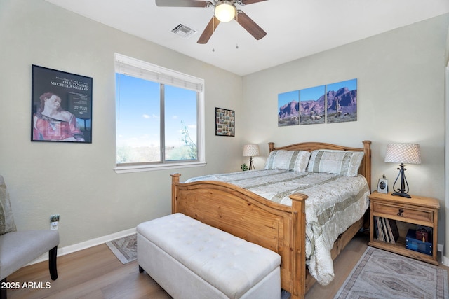 bedroom featuring visible vents, ceiling fan, baseboards, and wood finished floors