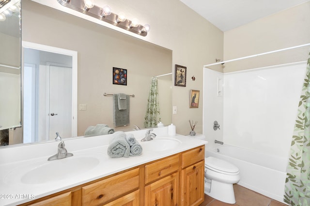 full bathroom with double vanity, toilet, a sink, and tile patterned floors