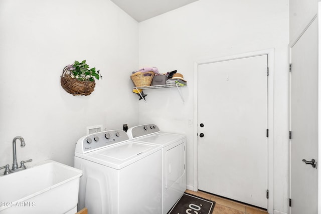 clothes washing area featuring laundry area, washing machine and clothes dryer, and a sink