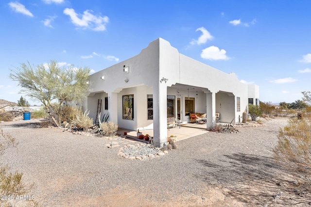 rear view of property featuring a patio area and stucco siding