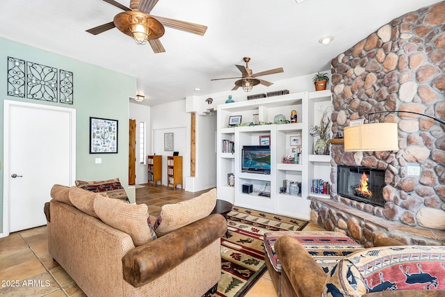 tiled living room featuring a stone fireplace and a ceiling fan