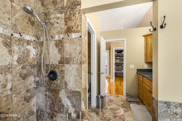4371 E Savannah Cir, Flagstaff, AZ 86004 - bathroom with a tile shower, lofted ceiling, vanity, and a spacious closet