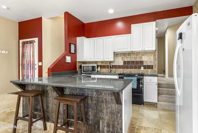 4371 E Savannah Cir, Flagstaff, AZ 86004 - kitchen with stainless steel microwave, freestanding refrigerator, white cabinets, a sink, and black electric range oven