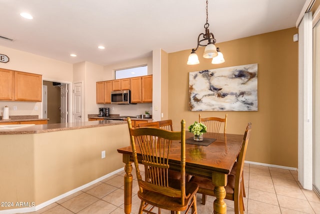 dining space with an inviting chandelier and light tile patterned flooring