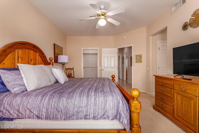 carpeted bedroom featuring a walk in closet, ceiling fan, and a closet