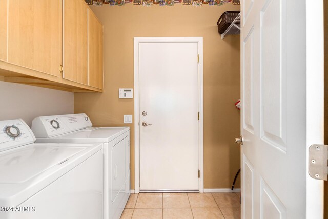 laundry area featuring cabinets, washer and clothes dryer, and light tile patterned flooring