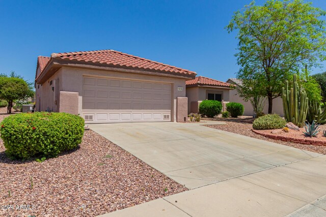 mediterranean / spanish home with a garage and central AC