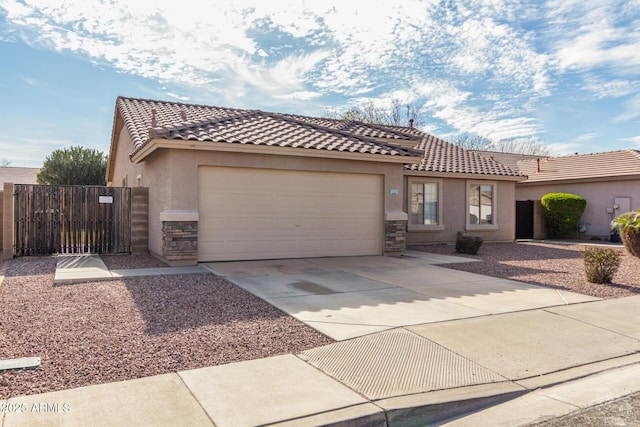 mediterranean / spanish-style home with stucco siding, an attached garage, stone siding, driveway, and a tiled roof