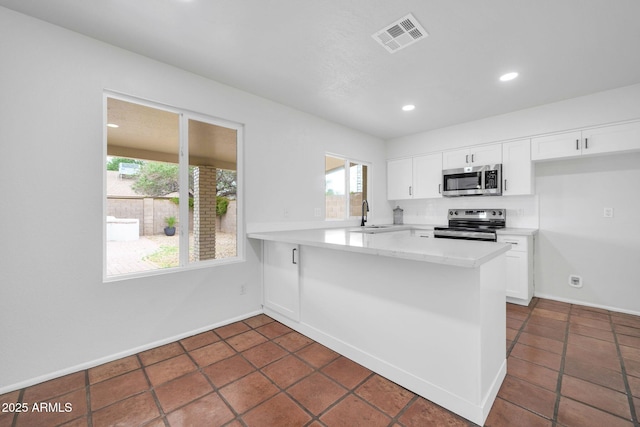 6527 W Sunnyside Dr, Glendale, AZ 85304 - kitchen with appliances with stainless steel finishes, white cabinetry, visible vents, and a healthy amount of sunlight