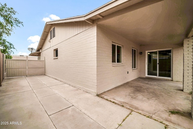 6527 W Sunnyside Dr, Glendale, AZ 85304 - view of side of home with a patio, a gate, fence, and brick siding