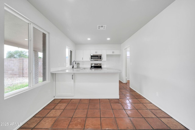 6527 W Sunnyside Dr, Glendale, AZ 85304 - kitchen featuring a peninsula, light countertops, white cabinets, visible vents, and stainless steel appliances