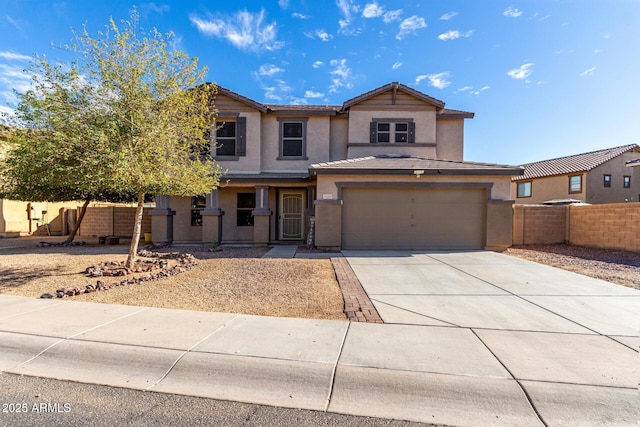 traditional-style home with driveway, a garage, fence, and stucco siding