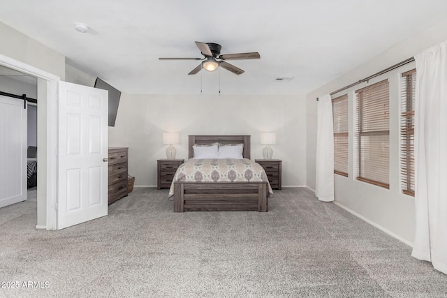 bedroom with visible vents, a barn door, a ceiling fan, carpet flooring, and baseboards