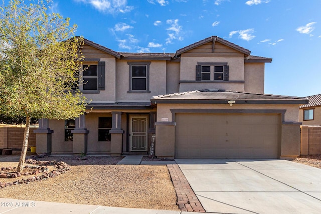 view of front of home featuring driveway, an attached garage, a tiled roof, and stucco siding