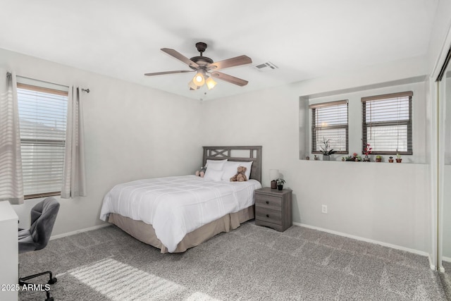 carpeted bedroom with a ceiling fan, visible vents, baseboards, and multiple windows