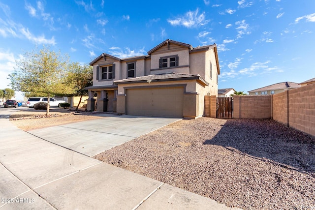 traditional-style house featuring stucco siding, concrete driveway, an attached garage, a gate, and fence