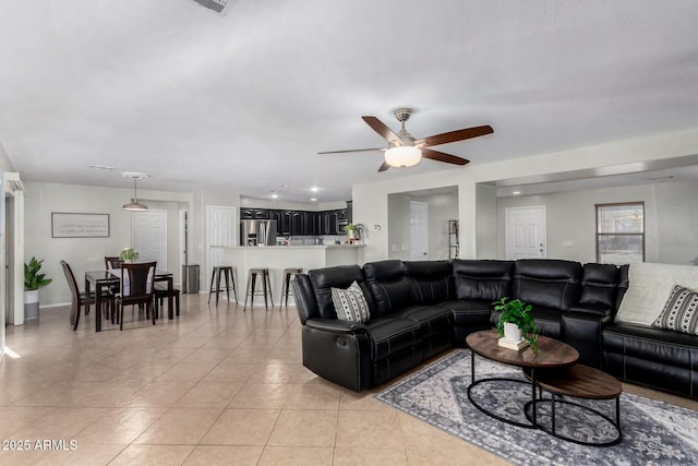 living room with light tile patterned flooring, a ceiling fan, and baseboards