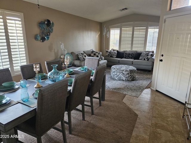 tiled dining area with a wealth of natural light and vaulted ceiling