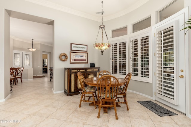 dining room featuring baseboards, light tile patterned floors, and crown molding