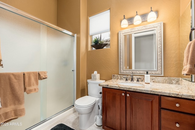 full bathroom with toilet, a textured wall, a shower stall, and vanity