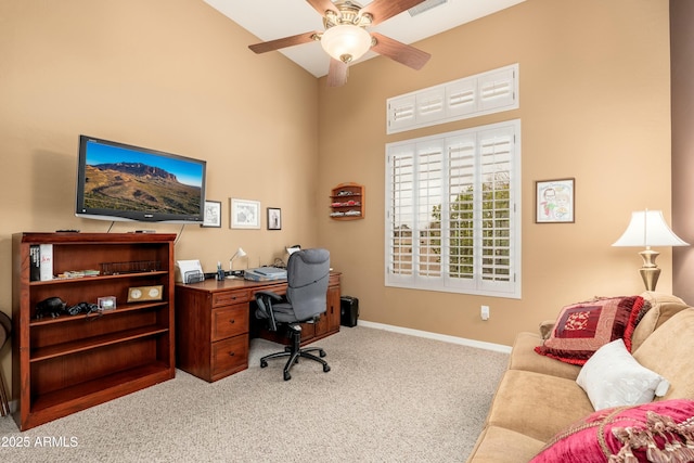 office area with a ceiling fan, light carpet, high vaulted ceiling, and baseboards