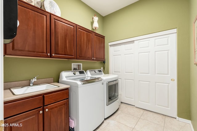 laundry area featuring cabinet space, light tile patterned flooring, a sink, and independent washer and dryer