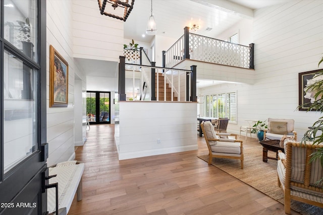 living room featuring a towering ceiling and light hardwood / wood-style flooring