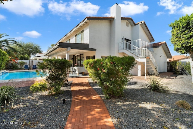 rear view of house featuring a patio area and a fenced in pool