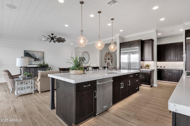 1145 E Gleneagle Dr, Chandler, AZ 85249 - kitchen featuring appliances with stainless steel finishes, a kitchen island with sink, a sink, recessed lighting, and light wood-type flooring