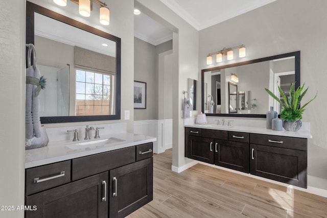1145 E Gleneagle Dr, Chandler, AZ 85249 - bathroom with ornamental molding, two vanities, wood finished floors, and a wainscoted wall