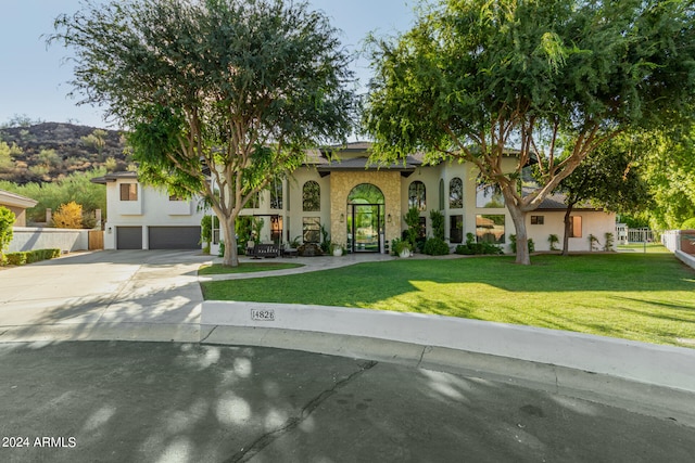 view of front of property with a mountain view, a front lawn, and a garage