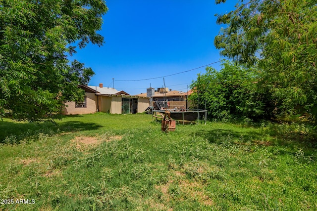 9353 W Monroe St, Tolleson, AZ 85353 - view of grassy yard featuring a trampoline