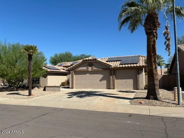 view of front of home with solar panels and a garage