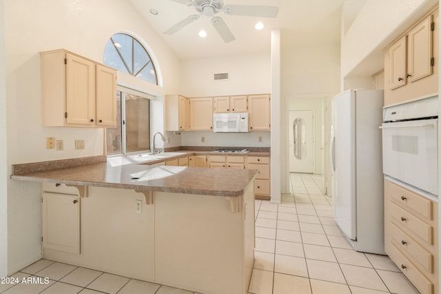 kitchen featuring white appliances, sink, kitchen peninsula, high vaulted ceiling, and light tile patterned floors