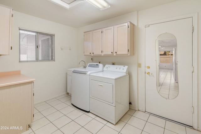 laundry room featuring sink, light tile patterned floors, cabinets, and separate washer and dryer