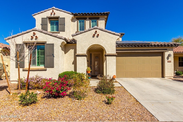 mediterranean / spanish-style house featuring driveway, an attached garage, a tile roof, and stucco siding