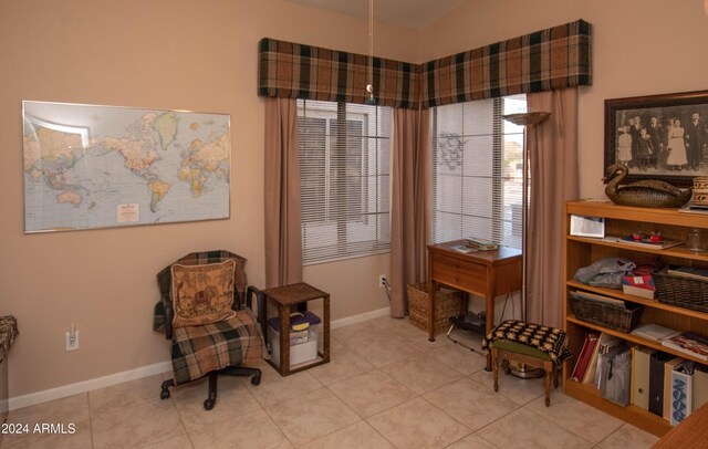 living area featuring lofted ceiling, baseboards, and tile patterned floors